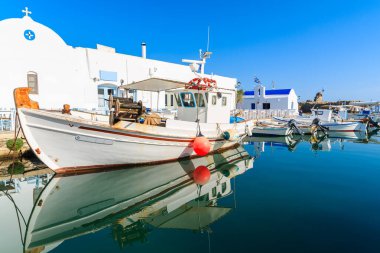Yunanistan 'ın Paros adasındaki Naoussa limanındaki küçük bir şapelin önünde demirleyen balıkçı teknesi
