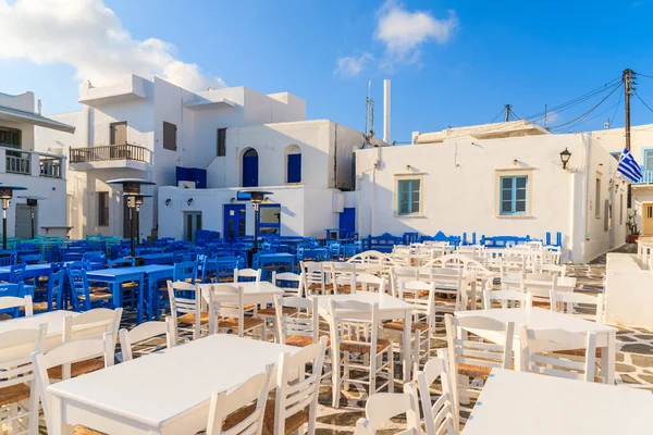 Yunanistan 'ın Paros adasındaki Naoussa limanındaki meydanda beyaz ve mavi meyhane masaları