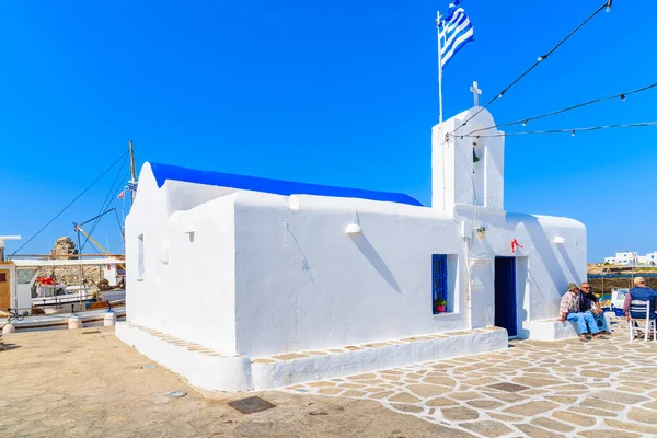 PAROS Adaları, GREECE - 20 Mayıs 2016: Yunanistan 'ın Paros adasındaki Naoussa limanında bir kilisenin önünde oturan balıkçılar.