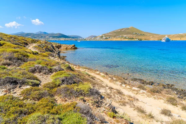 Yunanistan 'ın Paros adasındaki Monastiri körfezinde kristal berrak deniz suyu boyunca uzanan güzel kıyı yolu
