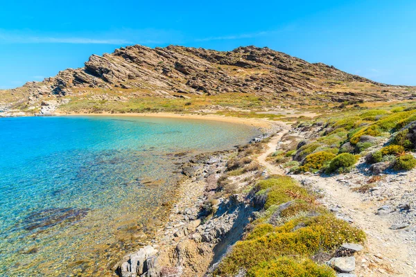 Yunanistan 'ın Paros adasındaki Monastiri körfezinde kristal berrak deniz suyu boyunca uzanan güzel kıyı yolu