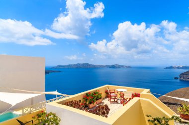 Yunanistan 'ın Santorini adasındaki güzel Firostefani köyünde deniz manzaralı terastaki sandalye ve masa