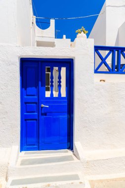 Yunanistan 'ın Santorini adasındaki Firostefani köyündeki tipik Yunan beyaz sarayına mavi kapılar