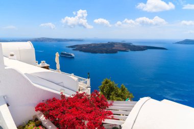 Yunanistan 'ın Santorini adasındaki Firostefani köyündeki bir evin terasındaki Caldera manzarası ve tipik kırmızı çiçekler