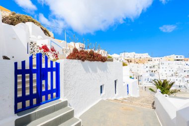 Dar sokaktaki mavi kapı ve Yunanistan 'ın Santorini adasındaki İmerovigli köyündeki tipik Yunan evleri