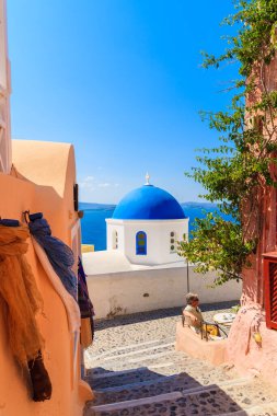 OIA VILLAGE, SANTORINI ISLAND - 23 Mayıs 2016: Yunanistan 'ın Santorini adası, mavi kubbeli beyaz kiliseleriyle tanınan ünlü Oia köyünde renkli evleri olan sokak.
