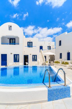 Yunanistan 'ın Santorini adasındaki Oia köyünde yüzme havuzlu tipik Yunan tarzı dairelerin manzarası