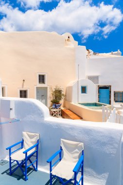 Yunanistan 'ın Santorini adasındaki Oia köyündeki tipik Yunan evlerinin teraslarındaki sandalyeler