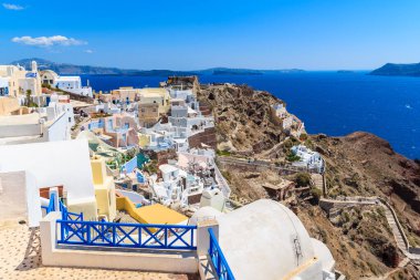 Uçurumun kenarına renkli evler inşa edilmiş Oia köyü manzarası, Santorini Adası, Yunanistan