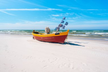 Kumlu Debki sahilinde renkli bir balıkçı teknesi, Baltık Denizi kıyısı, Polonya