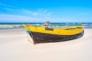 Kumlu Debki sahilinde renkli bir balıkçı teknesi, Baltık Denizi kıyısı, Polonya