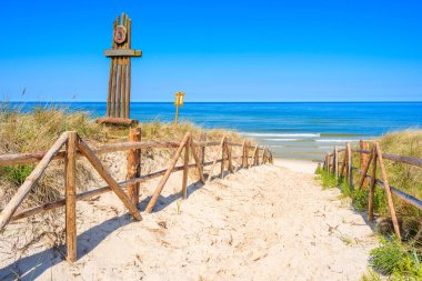 Polonya 'nın Lubiatowo köyü yakınlarındaki Baltık Denizi kıyısındaki kumlu plaja giriş.