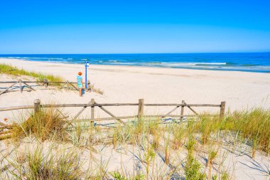 Genç bayan turist, Polonya 'nın Baltık Denizi kıyısındaki Lubiatowo sahil köyünün girişinde duruyor.
