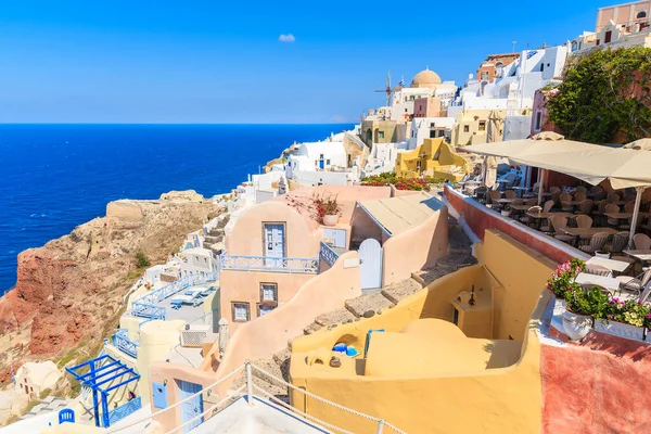 Renkli evleri ve restoran terası olan ünlü Oia köyü manzarası, Santorini Adası, Yunanistan