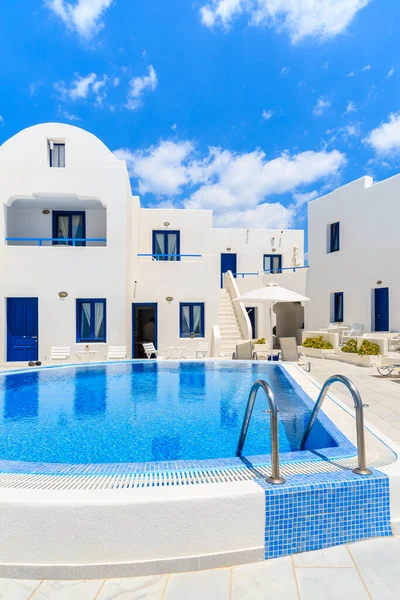 Yunanistan 'ın Santorini adasındaki Oia köyünde yüzme havuzlu tipik Yunan tarzı dairelerin manzarası
