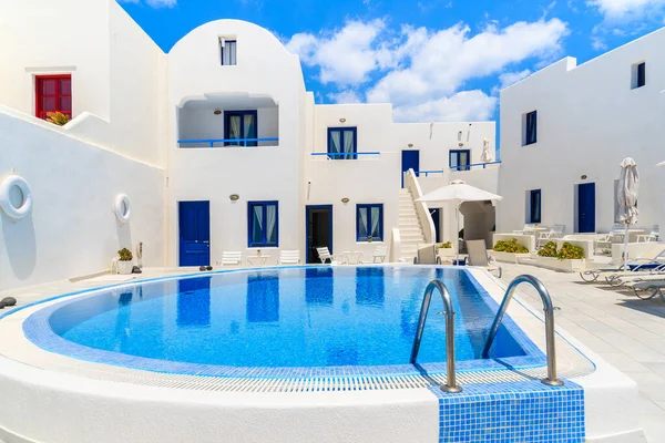 Yunanistan 'ın Santorini adasındaki Oia köyünde yüzme havuzlu tipik Yunan tarzı dairelerin manzarası