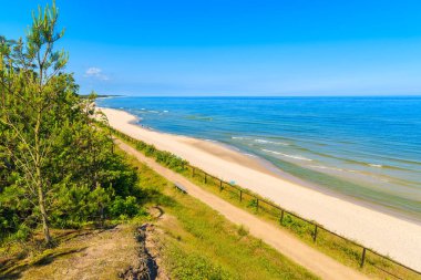 Jastrzebia Gora köyü, Baltık Denizi, Polonya 'daki güzel kumlu sahil boyunca uzanan kıyı yolu.