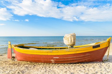 Güneşli yaz gününde, Kumlu Debki sahilinde renkli balıkçı teknesi, Baltık Denizi, Polonya