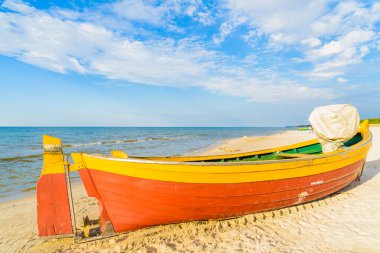 Güneşli yaz gününde, Kumlu Debki sahilinde renkli balıkçı teknesi, Baltık Denizi, Polonya