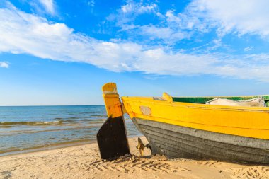 Güneşli yaz gününde, Kumlu Debki sahilinde renkli balıkçı teknesi, Baltık Denizi, Polonya