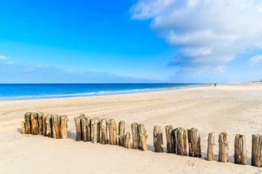 Almanya 'nın Sylt Adası' ndaki kumlu Kampen plajındaki tahta dalgalar.
