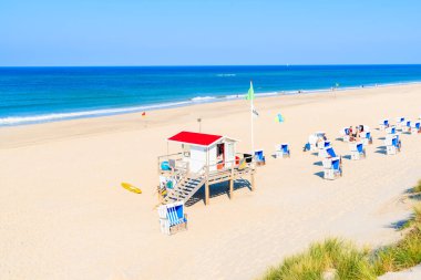 Almanya 'nın Sylt Adası' ndaki Westerland plajında cankurtaran kulübesi ve hasır sandalyeler
