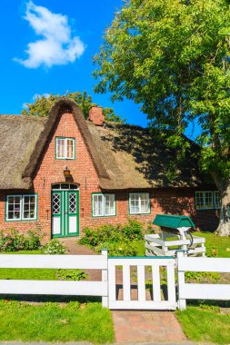 Almanya 'nın Sylt Adası' ndaki Keitum köyünde saman çatılı tipik kırmızı tuğlalı Frizya evi.