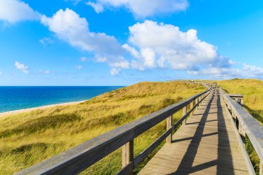 Almanya 'nın Sylt Adası' ndaki Wenningstedt köyündeki sahil boyunca uzanan tahta yol.