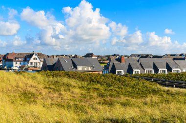 Wenningstedt köyündeki tipik evlerin önü Almanya 'nın Sylt adasında çimen kumuluyla kaplı.