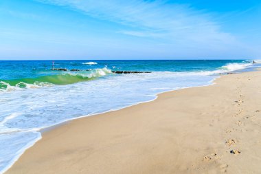 Almanya 'nın Sylt Adası yakınlarındaki Kampen köyünde beyaz kumsalda deniz dalgaları.
