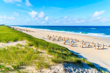 Wicker sandalyeleri ve kumlu kum tepeleri, Almanya 'nın Kuzey Denizi, Sylt Adası' ndaki Wenningstedt köyünde.