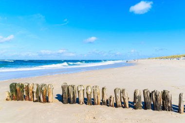 Güneşli yaz gününde, güzel kumlu sahilde, tahta dalgalar Almanya 'nın Sylt Adası' nda.