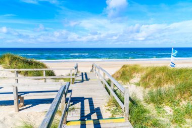 Almanya 'nın Sylt Adası' ndaki cennet kumlu plaja giden ahşap yol.