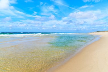 Almanya 'nın Sylt Adası' ndaki Kampen köyündeki güzel sahilde sığ deniz suyu ve beyaz kum.