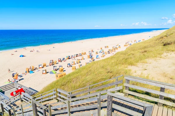 Kuzey Denizi kıyısında tahta yol ve Almanya 'nın Sylt Adası' ndaki Wenningstedt köyü yakınlarındaki güzel plaj manzarası.