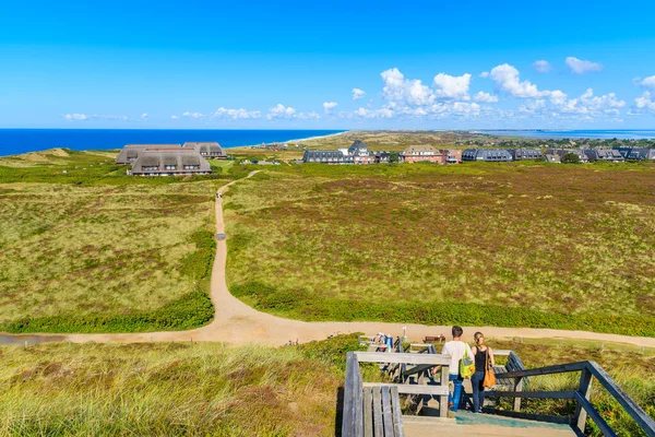 Almanya 'nın Sylt Adası' nın batı kıyısındaki Kampen köyünden aşağı doğru yürüyen insanlar