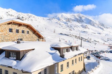 Avusturya 'nın Obertauern kışlık tatil beldesinde taze karla kaplı dağ oteli manzarası