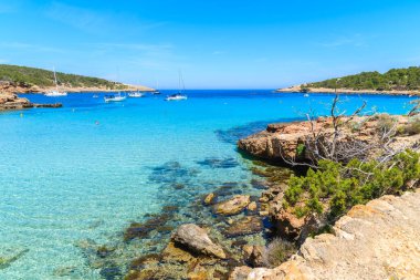 İspanya 'nın İbiza adasındaki kıyı güvertesinden Cala Portinatx Körfezi' ndeki gök mavisi deniz suyunun görüntüsü