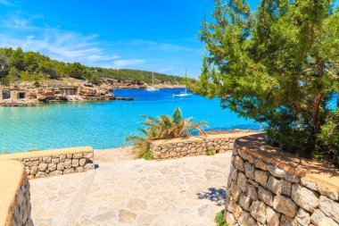 İspanya 'nın İbiza adasındaki Cala Portinatx Körfezi' ndeki mavi deniz boyunca uzanan kıyı şeridi manzarası