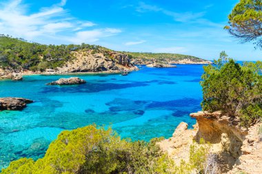 İspanya 'nın İbiza adasının kuzey kıyısındaki mavi deniz suyuyla Cala Xarraca körfezinin çarpıcı manzarası.