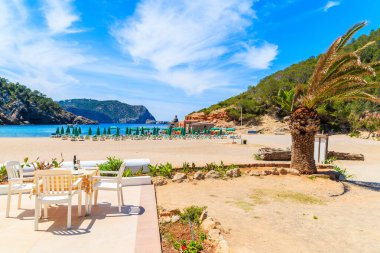 Cala Benirras sahilindeki güneşli terasta restoran masası, İbiza adası, İspanya