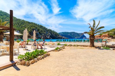 CALA BENIRRAS BEACH, IBIZA ADASI - 16 Mayıs 2017: Cala Benirras plajı, İbiza adası, İbiza 'daki terasta restoran masasında oturan bir sürü insan.