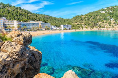 İspanya 'nın İbiza adasındaki Cala San Vicente körfezindeki deniz suyu ve otel binaları.