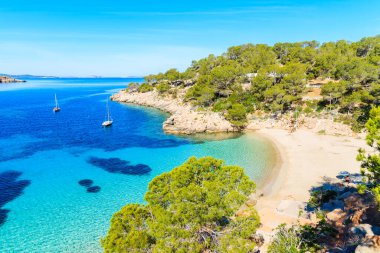 Masmavi kristal berraklığındaki deniz suyuyla ünlü Cala Salada koyu'ndaki güzel plajın manzarası, Ibiza adası, İspanya
