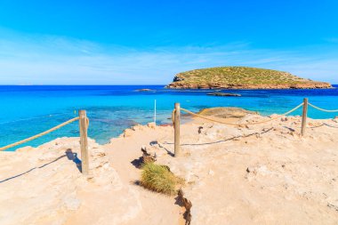 Güzel Cala Comte plajına giriş ve yol kristal berrak sığ deniz suyu, İbiza adası, İspanya