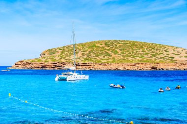 İspanya 'nın İbiza adasındaki Cala Comte Körfezi' nde mavi denizde katamaran teknesi.