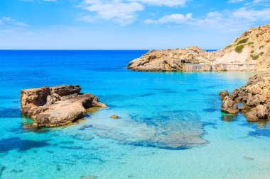 İspanya 'nın İbiza adasında turkuaz deniz suyunda kayalıklı Cala Tarida Körfezi manzarası