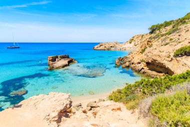 İspanya 'nın İbiza adasında turkuaz deniz suyunda kayalıklı Cala Tarida Körfezi manzarası