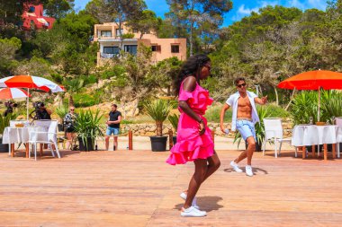 IBIZA Adaları, İspanya - 17 Mayıs 2017: İbiza 'nın güzelliği hakkında kısa bir film çekmek için Cala Carbo' daki sahil restoranının terasında dans eden iki genç.