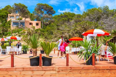 IBIZA Adaları, İspanya - 17 Mayıs 2017: İbiza 'nın güzelliği hakkında kısa bir film çekmek için Cala Carbo' daki sahil restoranının terasında dans eden iki genç.